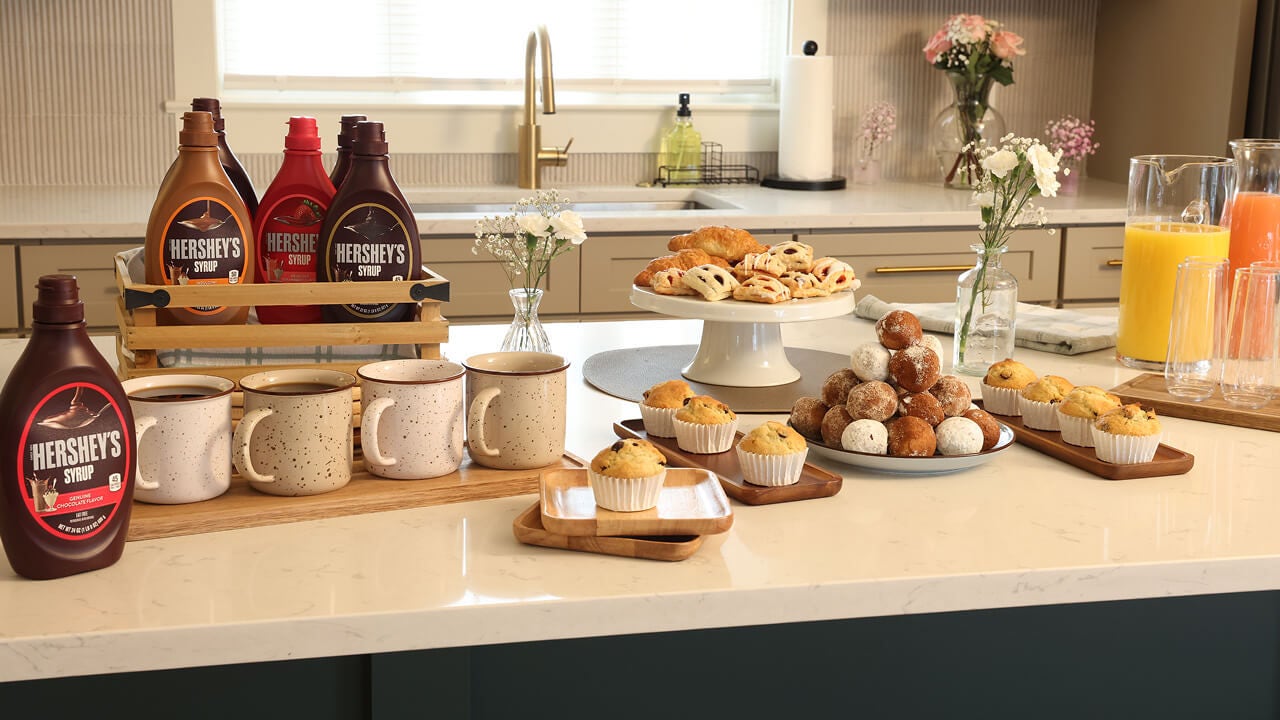 breakfast dessert table with flavored hersheys syrups and breakfast pasteries