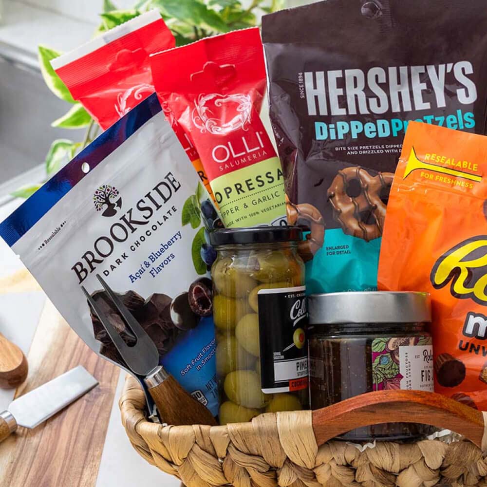 basket filled with assorted hersheys candies, olives, and jams