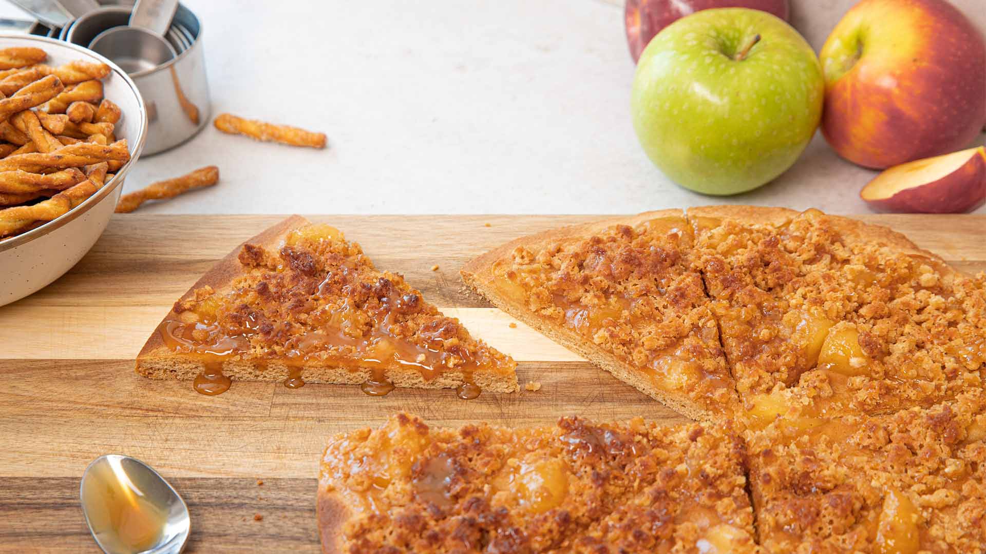 slicing and serving caramel apple dots pretzel crumble pizza
