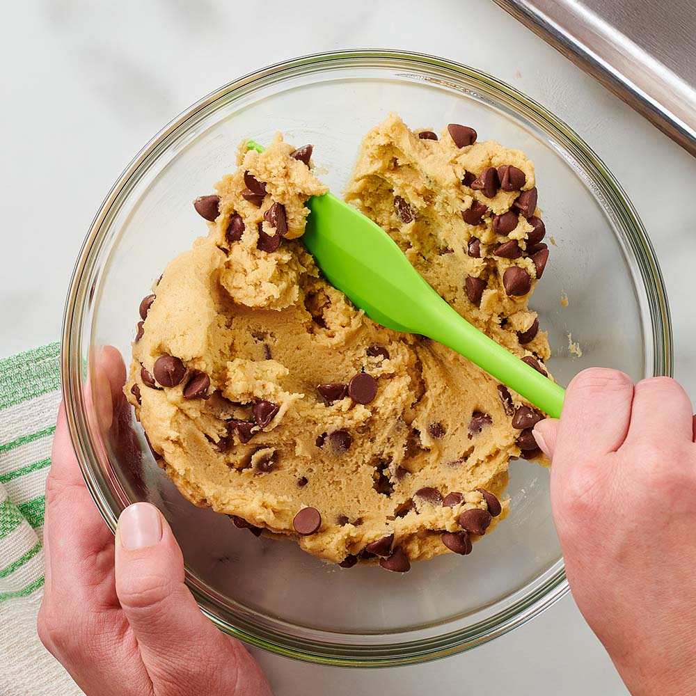 person mixing hersheys chocolate chips into batter