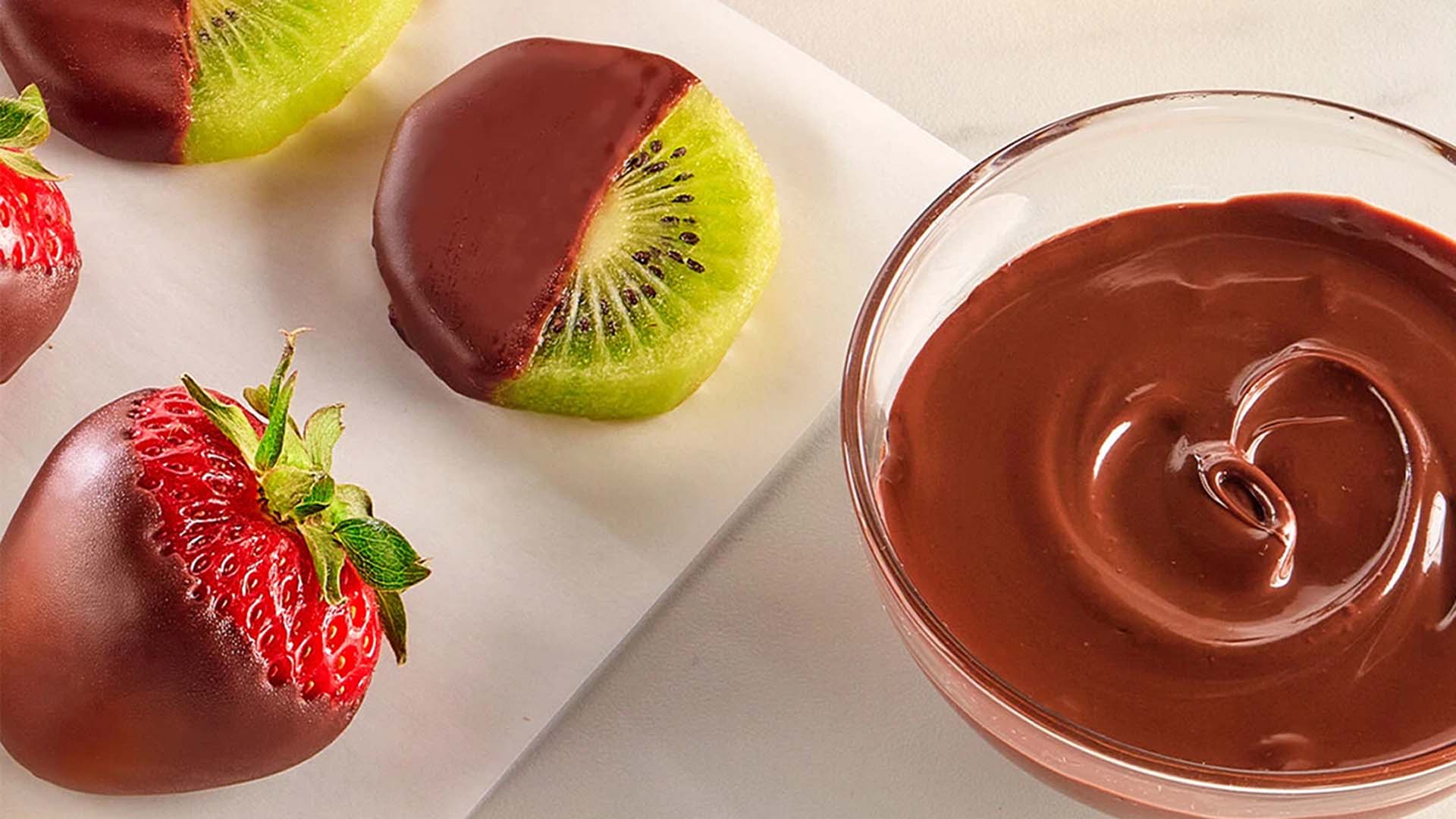 dipping fruit into bowl of melted chocolate