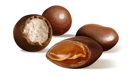 pile of unwrapped milk duds and whoppers candy