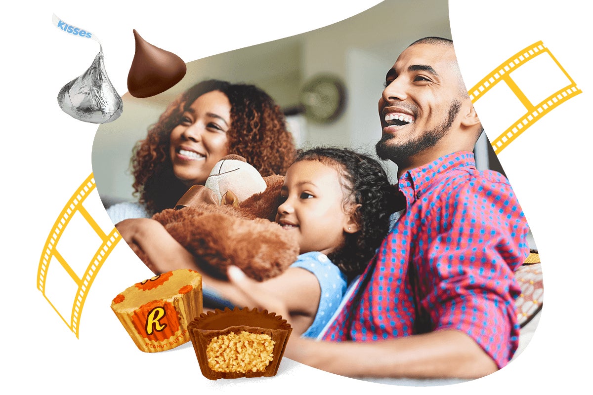 smiling family sitting on couch with hersheys kisses and reeses peanut butter cups