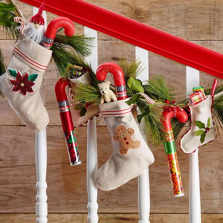 stuffed christmas stockings hanging from railing
